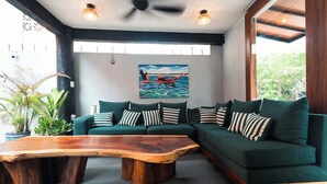 A modern living room with a sectional sofa, a wooden coffee table, and a painting on the wall. - Zihua Mia Hotel Boutique 3 (Zihuatanejo)