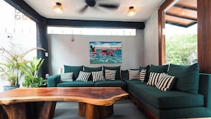 A modern living room with a sectional sofa, a wooden coffee table, and a painting on the wall. - Zihua Mia Hotel Boutique 5 (Zihuatanejo)
