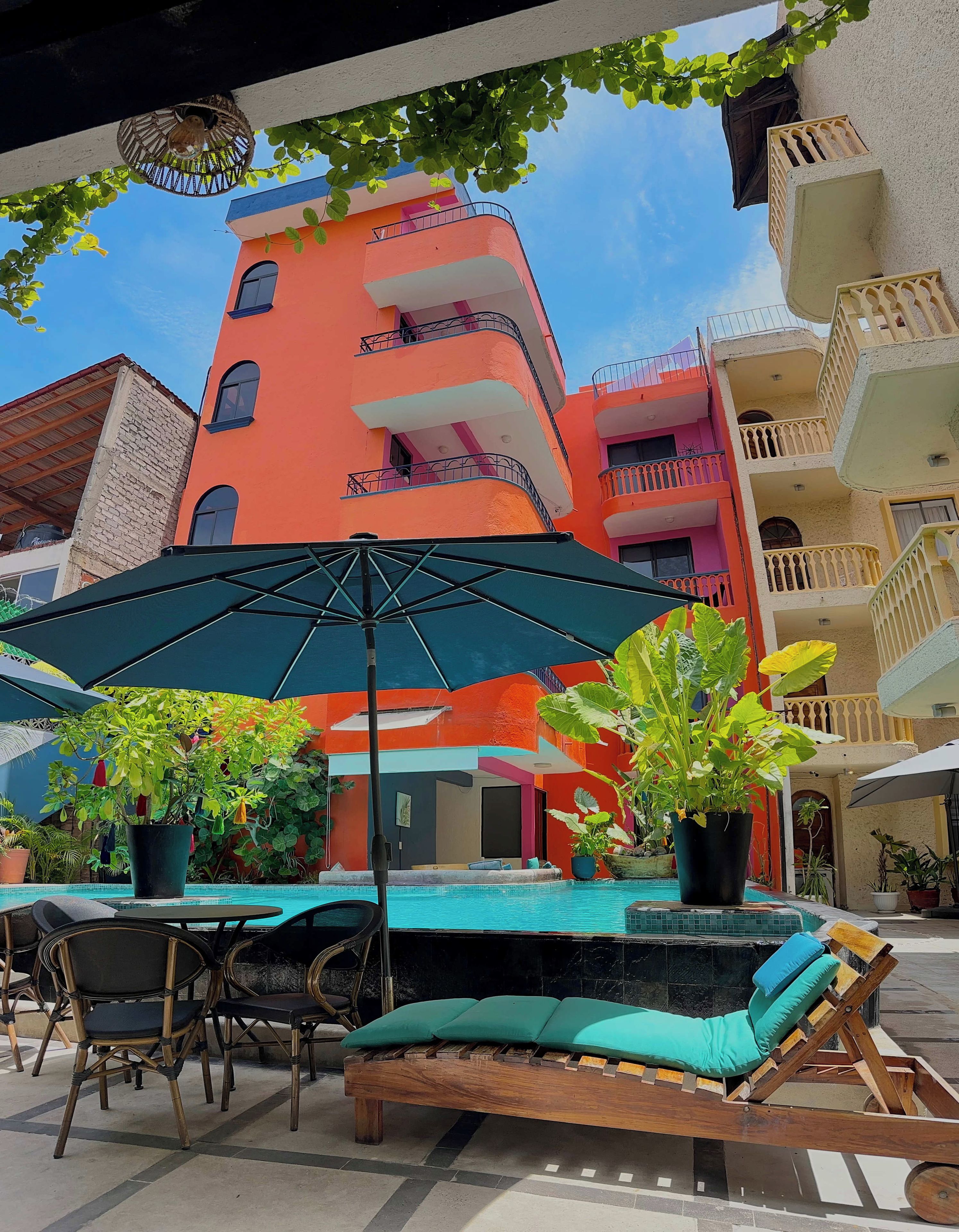 Un espace aménagé au bord de la piscine, avec des chaises longues, une table et des parasols.
