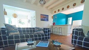 A living room with a sofa, a coffee table, and a kitchen area in the background. - pleasant villa of 120 qm for 8 people (BISCARROSSE)