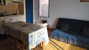 Una habitación compacta con cocina, una mesa de comedor y un sofá.