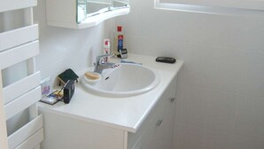 A bathroom with a white sink, mirror, and cabinet. There is a window providing natural light. - Beautiful duplex apartment of around 55m² for 4 people (BISCARROSSE)