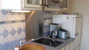 A compact kitchen with a granite countertop, a wooden sink, and a white refrigerator. - Beautiful duplex apartment of around 55m² for 4 people (BISCARROSSE)