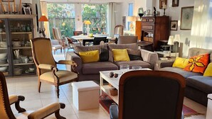 A spacious living room with a sofa set, armchairs, and a dining area with a table and chairs. - pleasant villa of around 130m² for 7 people (BISCARROSSE)