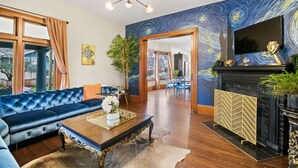 A living room with a blue sofa, a wooden coffee table, and a fireplace. - Casa Van Gogh: a Historic N. Slope retreat (Tacoma)