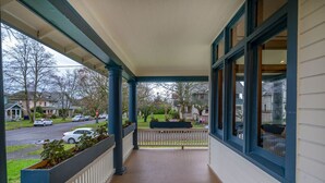 A covered porch with a view of a residential street. - Casa Van Gogh: a Historic N. Slope retreat (Tacoma)
