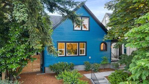Ein blaues Haus mit einem Fenster und einem kleinen Garten.