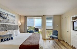 Relax in this serene retreat with a large bed, sliding glass door to a balcony, and stunning ocean views.