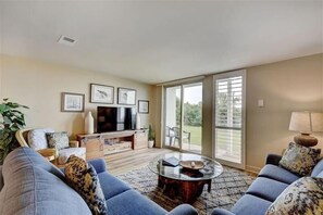 Relax in a stylish living room with a sofa, armchairs, and a flat-screen TV.