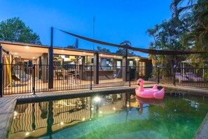 Relax by the pool surrounded by lush greenery and enjoy the tranquil atmosphere.