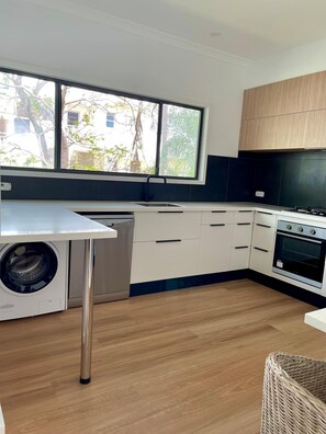 Enjoy a kitchen with a large window, washing machine, and stainless steel oven.
