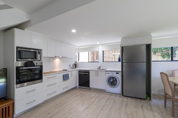 Enjoy cooking in this well-lit kitchen with appliances and a large window offering a view of the outdoors.