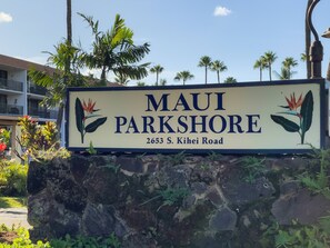 A sign for 'Maui Parkshore' at 2653 S. Kihei Road, featuring a tropical plant illustration.