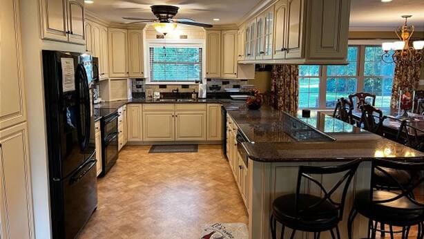 A spacious kitchen with high ceilings, a large island, and a view of the outdoors.