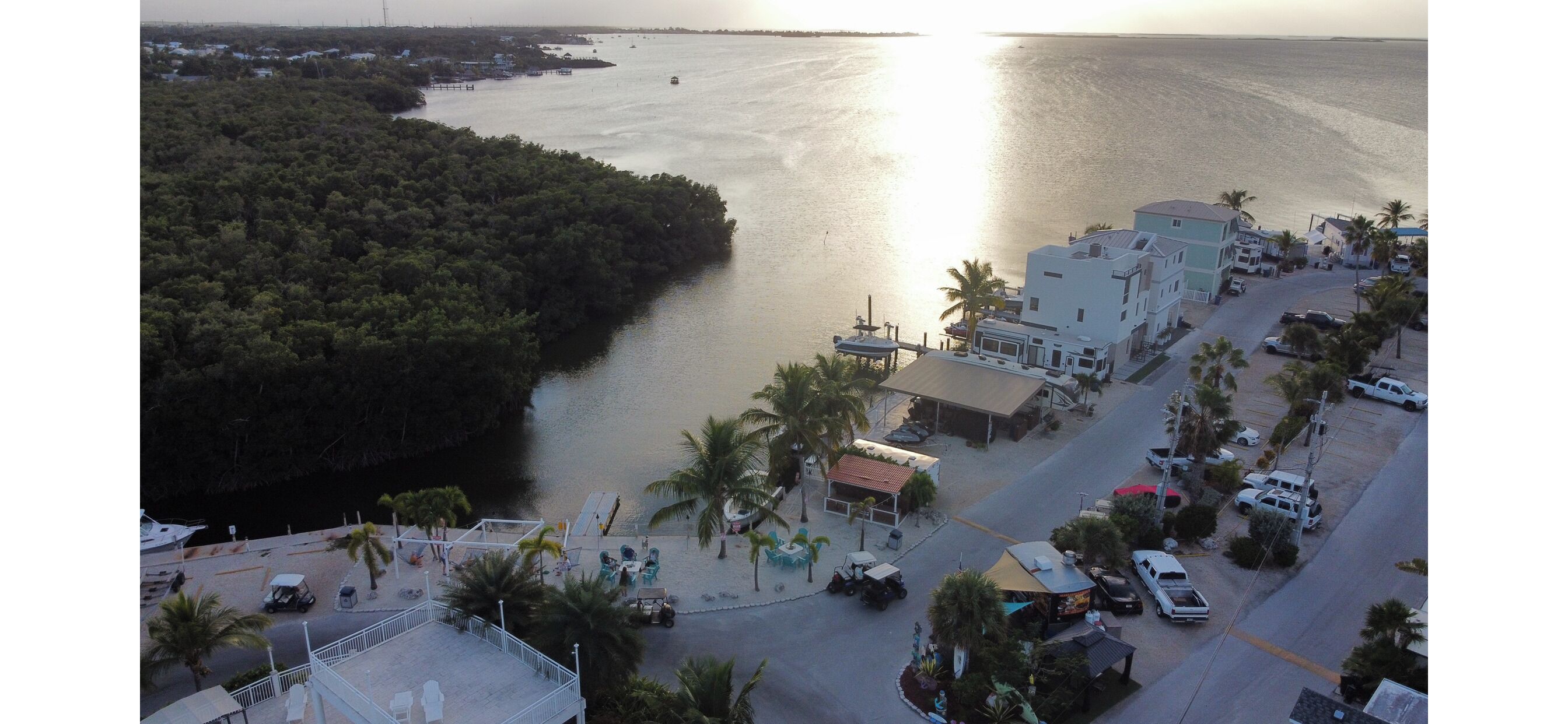 A coastal area with a marina, buildings, and a road.