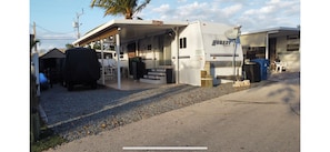 A Hornet RV with a covered porch, a satellite dish, and a 'Welcome' sign. - Perfect little paradise spot in key largo Florida.     (lot 15) (Key Largo)