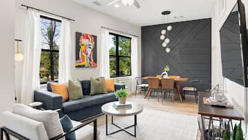 A modern living room with a sofa, coffee table, and dining area.