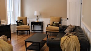 Una sala de estar con dos sillones, un sofá, una mesita de centro y una lámpara.