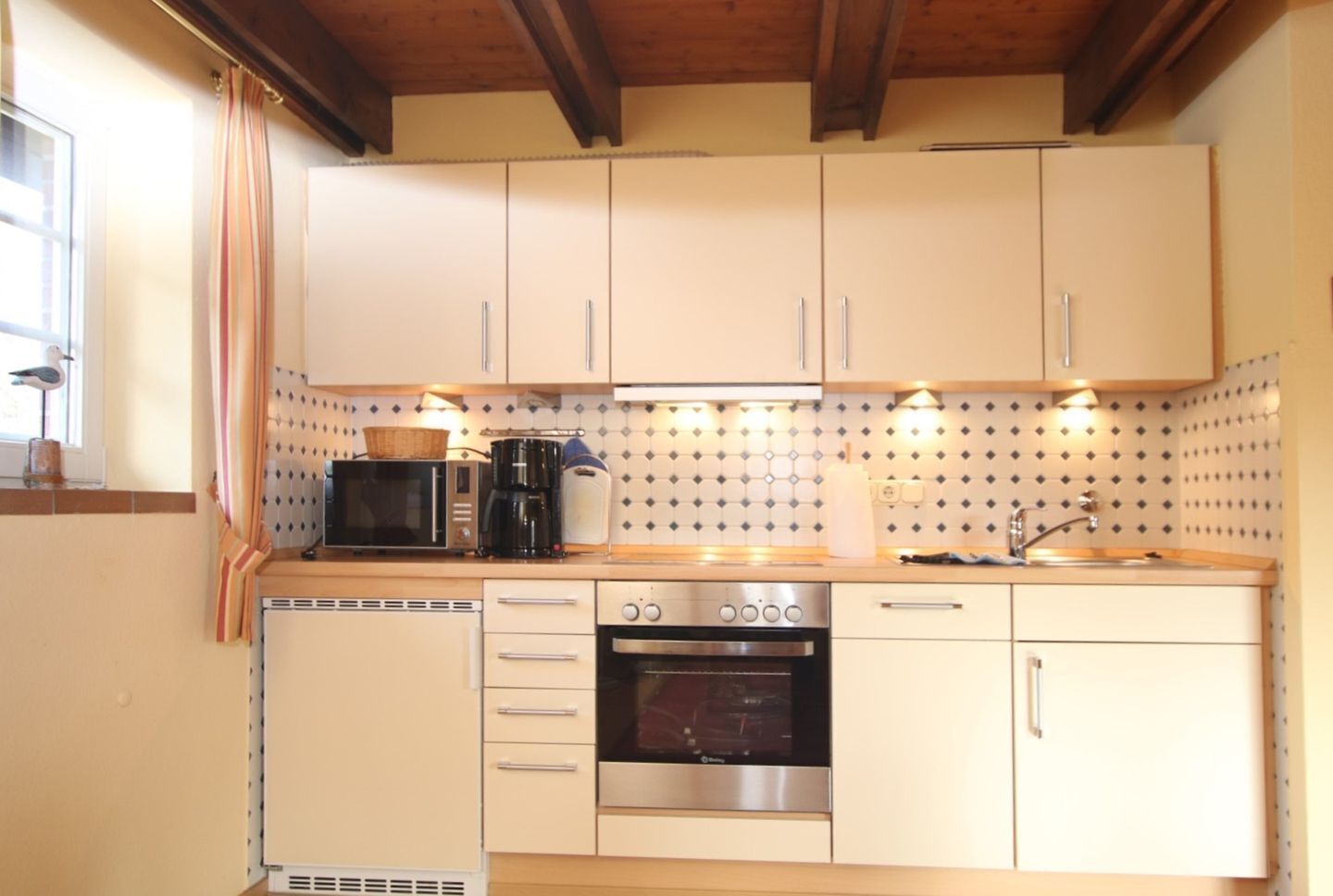 A compact kitchen with a microwave, coffee maker, toaster, and oven.