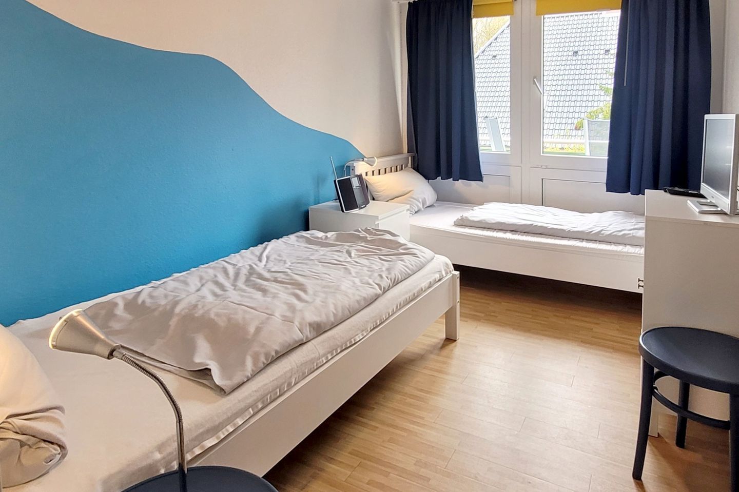 Ein Schlafzimmer mit zwei Betten, einem Schreibtisch und einem Stuhl.