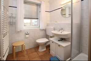 Un baño con inodoro, lavamanos y ducha.
