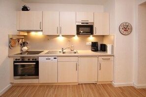 A compact kitchen with a Siemens oven, a microwave, a coffee maker, and a sink.
