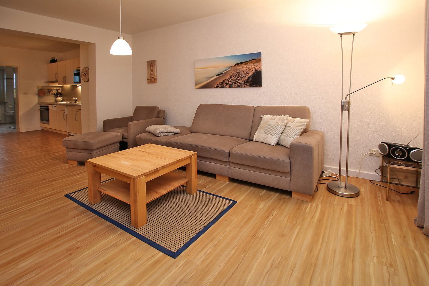 A living room with a sofa, a coffee table, a floor lamp, and a painting on the wall.