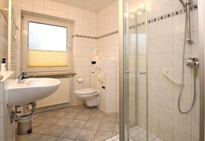 A bathroom with a sink, toilet, and glass-enclosed shower.