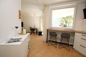 Uma cozinha compacta com área de refeições, uma janela com vista e um radiador.