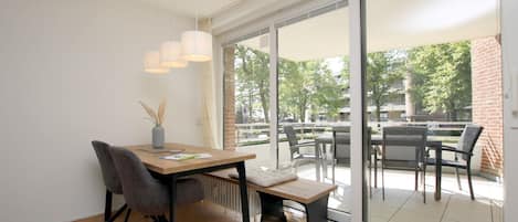 Un comedor moderno con una mesa de madera, sillas y lámparas colgantes.