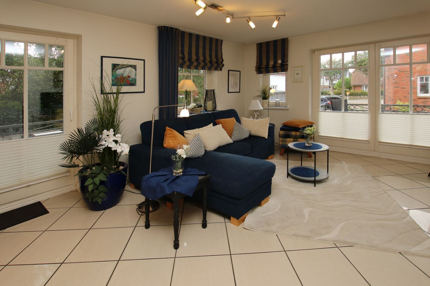 A living room with a sofa, a coffee table, a lamp, and a potted plant.