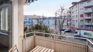 Un balcon donnant sur un paysage urbain, avec des bâtiments et une route.