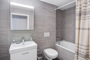 Ein modernes Badezimmer mit Dusche, Toilette und Waschbecken.