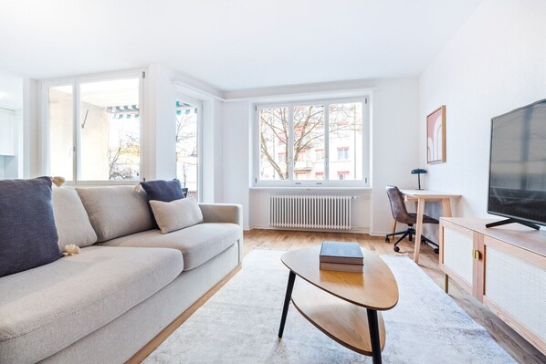 A modern living room with a sofa, coffee table, and TV.