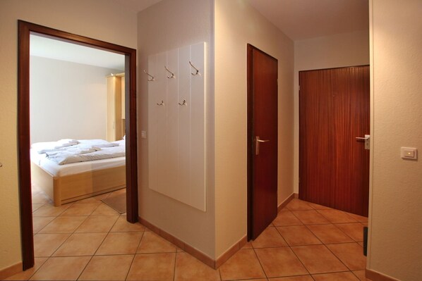 Quarto de hotel com cama, guarda-roupa e porta.