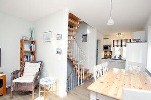 Un intérieur moderne comprenant un coin repas, un escalier, une cuisine et une bibliothèque.