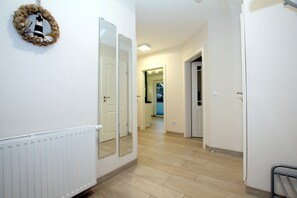 A hallway with a radiator, a mirror, and a door leading to another room. - Fehrstieg 40a - Freistehendes 5 Sterne-ferienhaus mit 4 Zimmern, ca. 131m², Garten und Terrasse (Wyk auf Föhr)