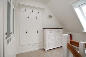 A room with a white wardrobe, a wooden staircase, and a window. - Starklef 34a, Whg. 2, Huus Starklef - Komfort Ferienwhg. in Wyk, 4 Personen, OG in 2- Familienhaus, (Wyk auf Föhr)
