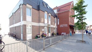 A building with a brick facade, a sign reading 'GASTEHAUS GORCH FOCK,' and a row of bicycles parked outside. - Sandwall 11a, Whg. 2 "Gästehaus Gorch Fock" - vacation apartment with 2 rooms on (Wyk auf Föhr)