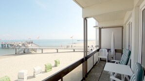 A balcony with a view of the beach, a pier, and a clear sky. - Sandwall 11a, Whg. 3 "gästehaus Gorch Fock" - Ferienwohnung mit 2- Zimmern auf ca. 42m² mit Direktem (Wyk auf Föhr)