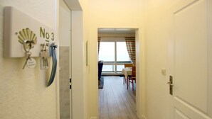 A hallway leading to a dining area with a view of the sea. - Sandwall 11a, Whg. 3 "gästehaus Gorch Fock" - Ferienwohnung mit 2- Zimmern auf ca. 42m² mit Direktem (Wyk auf Föhr)