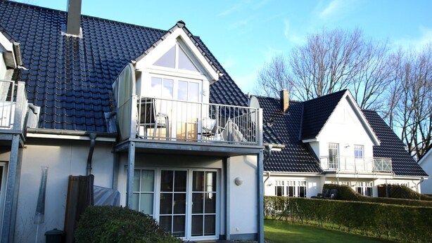 A two-story house with a balcony, a garage, and a well-maintained lawn. - Wiesenweg 4, Whg. 4, Druummeere - Holiday apartment with 3 rooms on approx. 100 m² (Wyk auf Föhr)