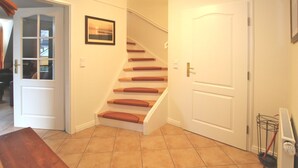 A staircase with wooden steps and red cushions, leading to a white door. - Wiesenweg 4, Whg. 4, Druummeere - Holiday apartment with 3 rooms on approx. 100 m² (Wyk auf Föhr)