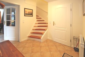 A staircase with wooden steps and red cushions, leading to a white door. - Wiesenweg 4, Whg. 4, Druummeere - Holiday apartment with 3 rooms on approx. 100 m² (Wyk auf Föhr)