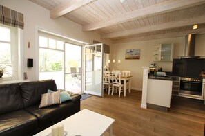 Een moderne keuken met een ingebouwde oven en een eethoek met een tafel en stoelen.