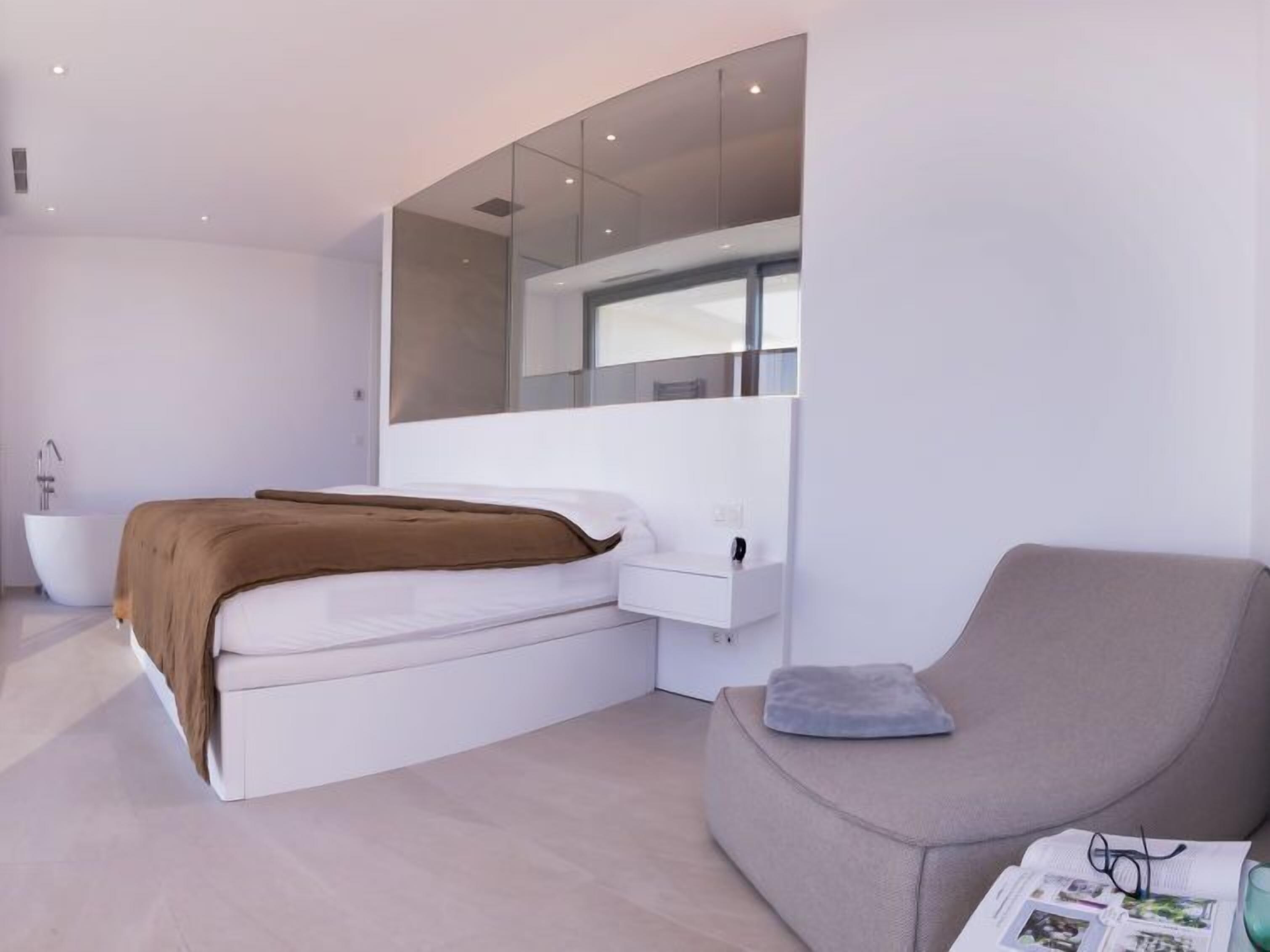 Une chambre à coucher moderne avec un lit, une table de chevet et une chaise.