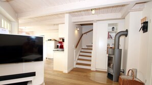 Een moderne keuken met een inbouwoven en een grote televisie.