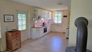 A kitchen with white cabinets, a microwave, a coffee maker, and a sink. - Strandstraße 77a, Haus Nordseeluft - House half with 120m² over 3 floors (Wyk auf Föhr)