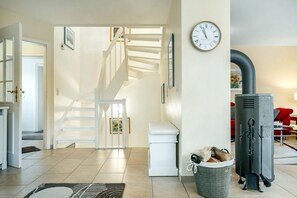 Ein modernes Wohnzimmer mit Treppe, Kamin und einer Wanduhr.