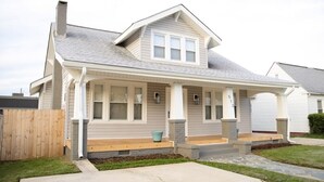 A two-story house with a front porch, a chimney, and a number '513' on the side. - Charming Remodeled 4 Bedroom Home in Downtown High Point (High Point)